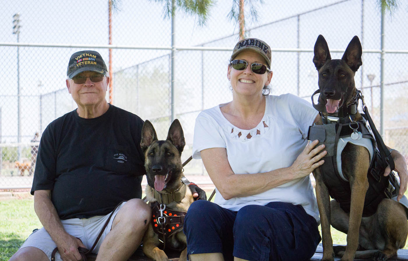 Two loving dobermans with their owners - if you are in need of doberman pinscher training in Lowell, MA contact Dog Training Elite today!.