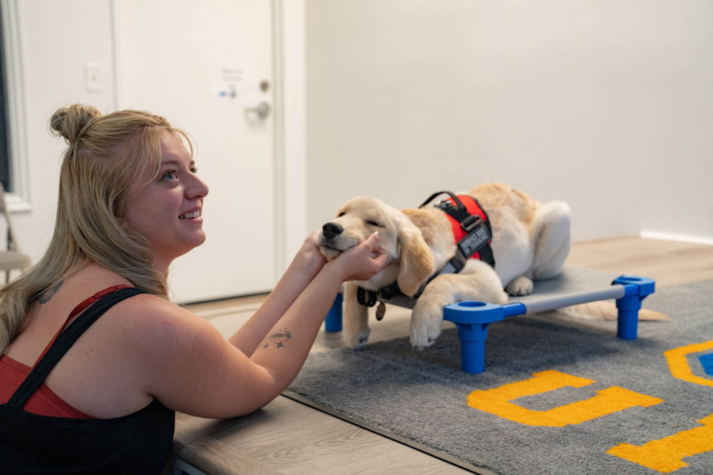 A dog owner and her service puppy - we offer balanced training programs at Dog Training Elite in Tampa, FL.